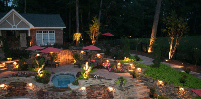 Outdoor image of a house with lighted landscape. Quote - Indoor and out, EF Electric will light up your world.